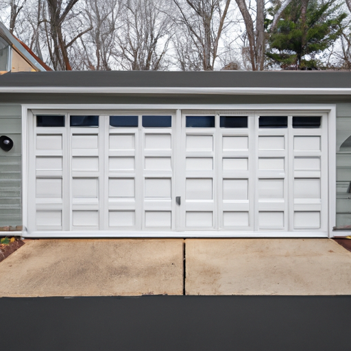 Suburban Tewksbury home with a closed insulated sectional garage door, visible weather seal and driveway.