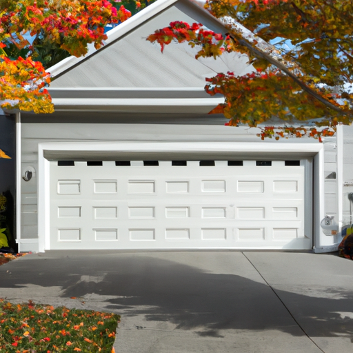 Residential steel sectional garage door in Tewksbury, MA with autumn foliage, driveway visible, no people.